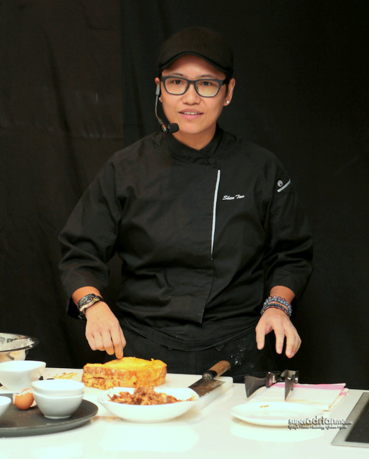 Chef Shen Tan demonstrating her Kong Bak French Toast dish at the media preview in Singapore.