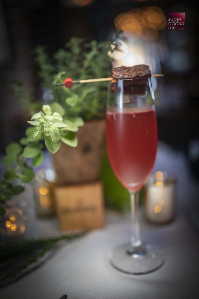 Natural sandstone rock sparkling water infused with Pukka Elderberry & Echinacea topped with an orange zest beetroot roasted cake. - OSO Ristorante