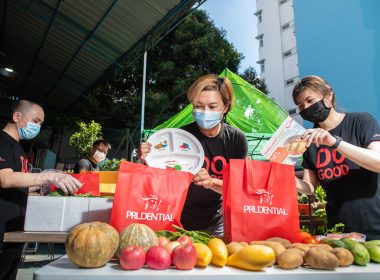 Prudential employee Ms Ariel Ong assembling a care pack consisting of fresh produce, a “Healthy Plate”, and a recipe card, together with her colleagues.